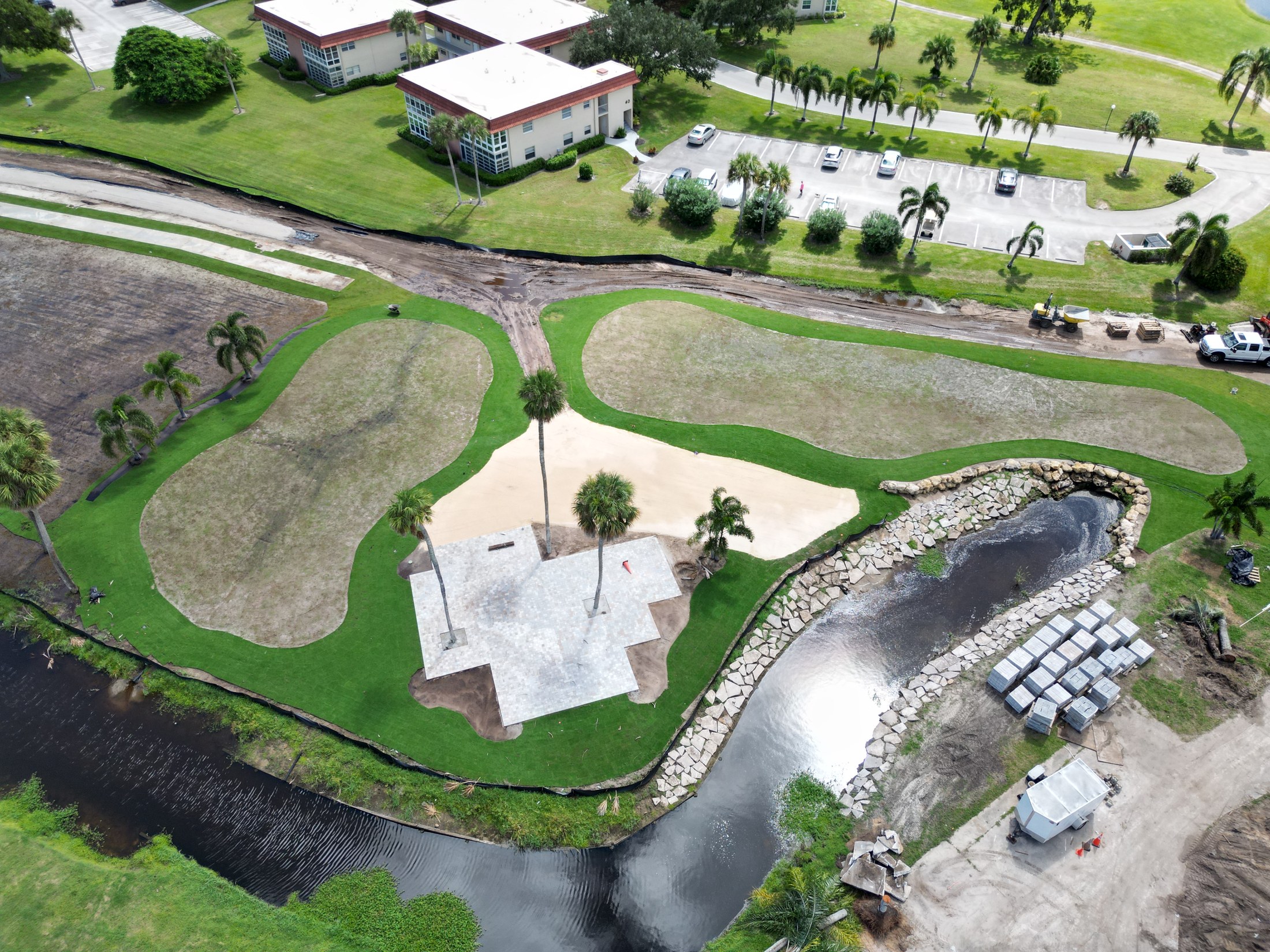 Aerial view of finished golf features and a stone-edged water feature