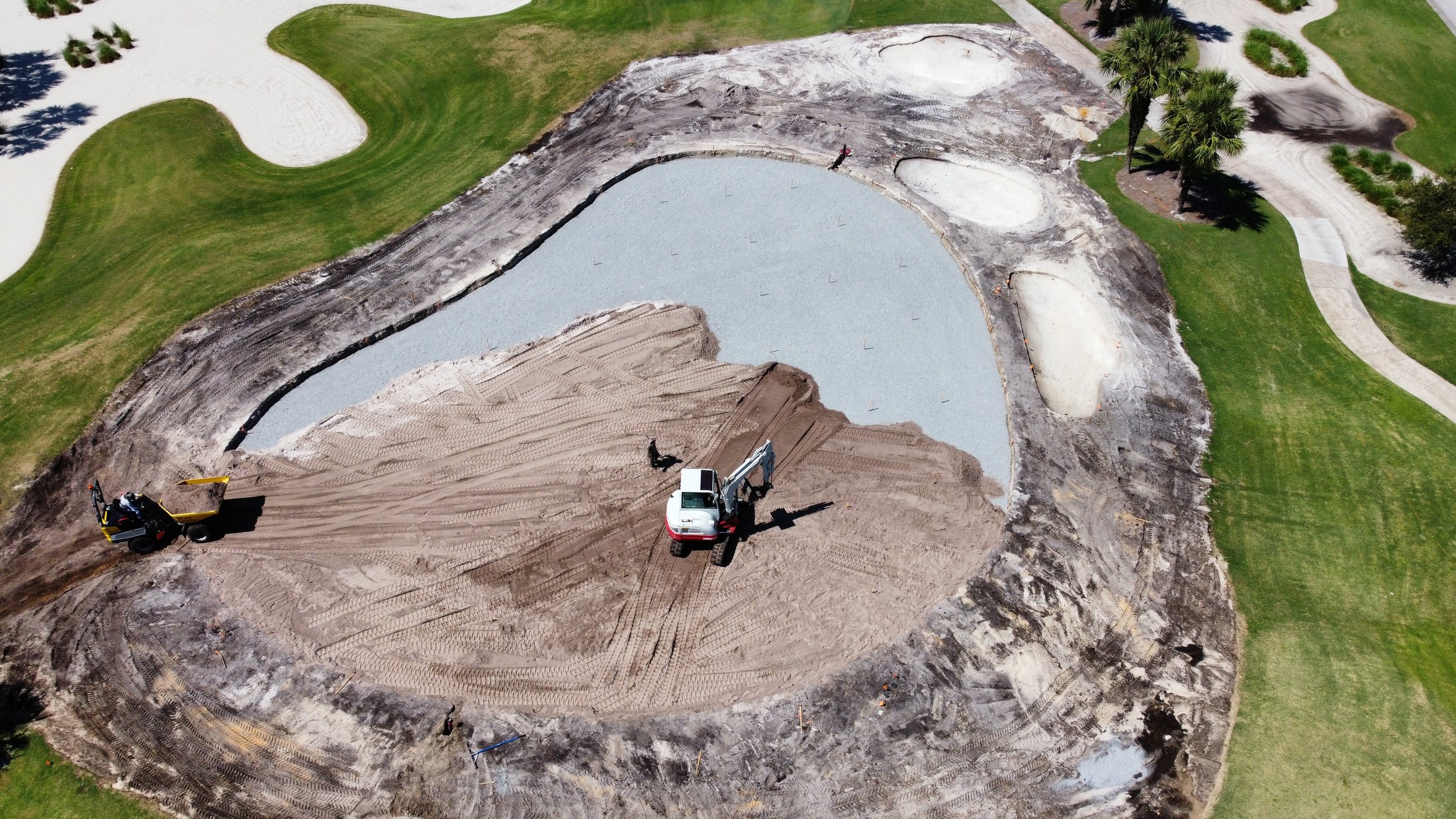 Aerial view of active earthwork beside a pond at Orchid Island Golf & Beach Club