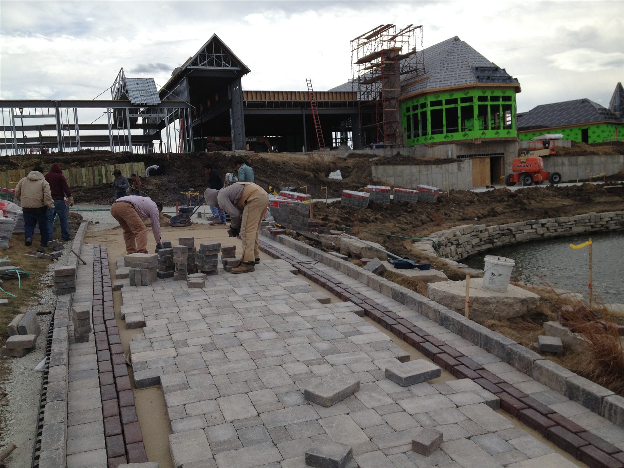 Crew installing pavers on an active construction site