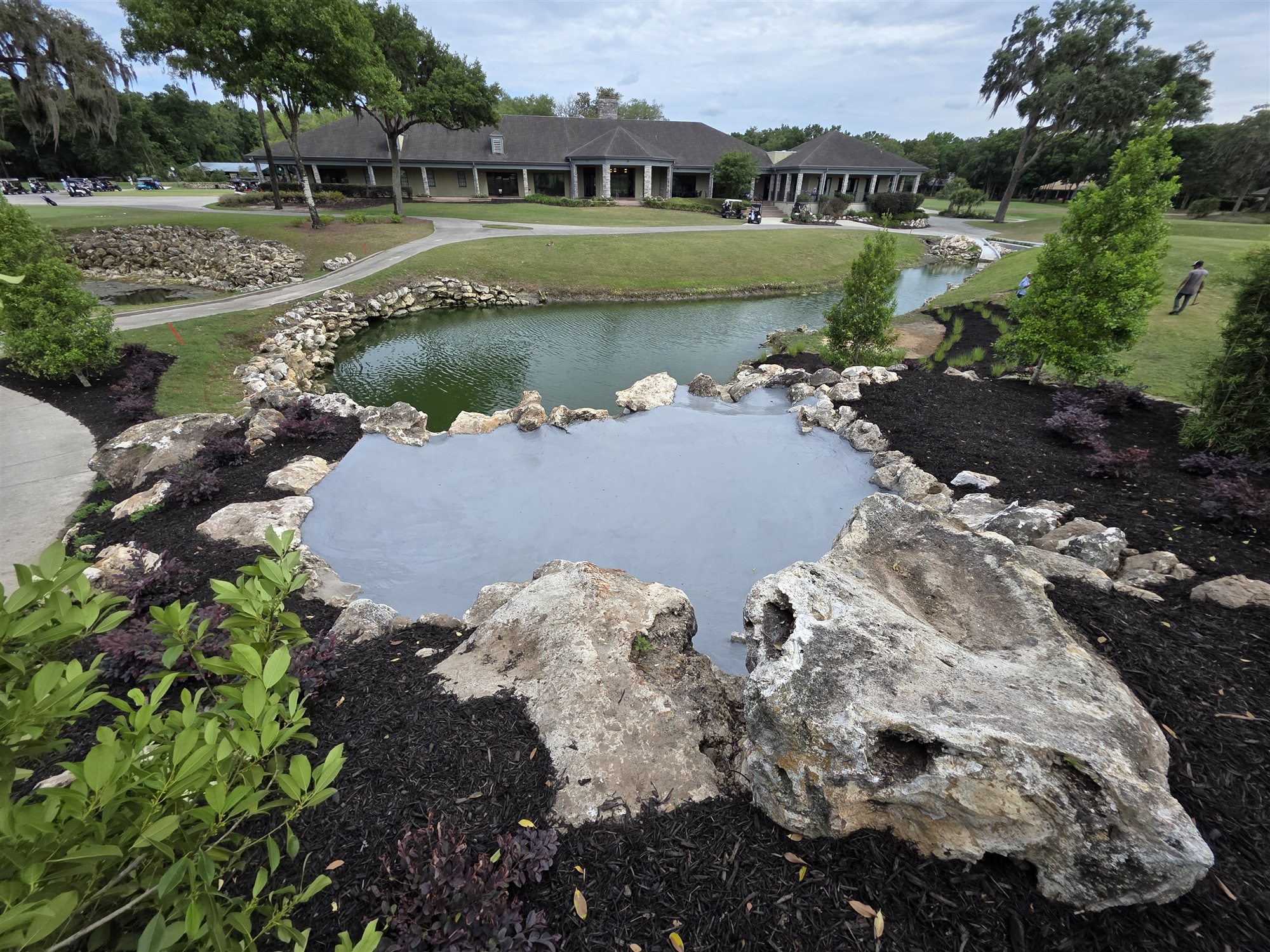 Stone-edged water feature within a golf course landscape